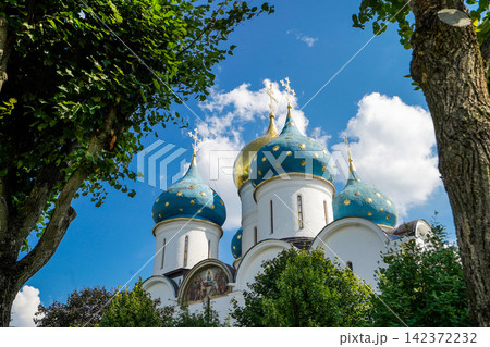 Orthodox Church Blue Onion Domes Framed by Green Trees Orthodox Church Blue Onion Domes Framed by Green Trees 142372232