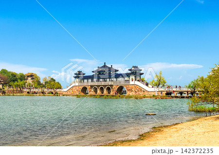 Chinese Pavilion Bridge Over Scenic Lake in Traditional Park 142372235
