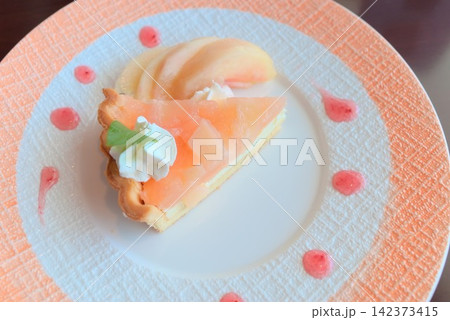 桃をたっぷりのせたタルトとクリームを華やかに盛り付けたデザート 桃をたっぷりのせたタルトとクリームを華やかに盛り付けたデザート 142373415