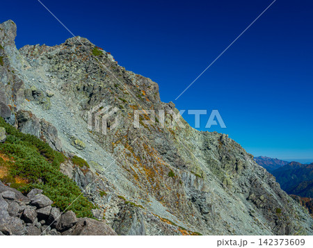 9月下旬の澄み渡る青空が広がる北穂高岳の荒々しい岩肌と山頂直下に佇む北穂高小屋 9月下旬の澄み渡る青空が広がる北穂高岳の荒々しい岩肌と山頂直下に佇む北穂高小屋 142373609