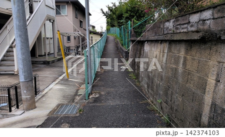 坂になった狭い通路と擁壁のある住宅地 坂になった狭い通路と擁壁のある住宅地 142374103