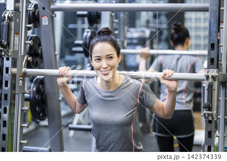 スポーツジムでトレーニングする若い女性 スポーツジムでトレーニングする若い女性 142374339