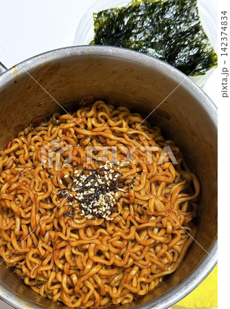 Savory jjapagetti noodles with a rich black bean sauce, topped with green onions and sesame seeds. A comforting Korean favorite that combines depth and flavor in each bite. 142374834