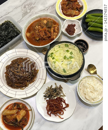 A vibrant spread of Korean food on the table, featuring various banchan (side dishes) like kimchi, pickled vegetables, and seasoned greens. Perfect for food photography, showcasing traditional Korean. A vibrant spread of Korean food on the table, featuring various banchan (side dishes) like kimchi, pickled vegetables, and seasoned greens. Perfect for food photography, showcasing traditional Korean. 142374857