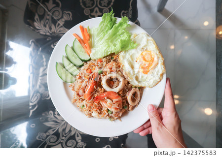 fried rice or stir-fried rice with shrimp , squid and fried egg or sunny side up egg fried rice or stir-fried rice with shrimp , squid and fried egg or sunny side up egg 142375583