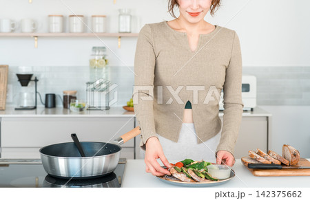 自宅のキッチンで健康的な食事の準備をする女性 自宅のキッチンで健康的な食事の準備をする女性 142375662