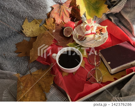 Cozy Autumn Flatlay with Coffee, Meringue Fig Dessert, Book, and Autumn Leaves 142376286