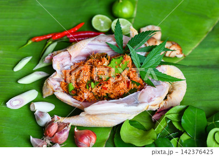 Cannabis food for cooking with fresh chicken cannabis leaf marijuana vegetables herbs and spices ingredients on banana leaf background, raw chicken hemp leaf plant THC CBD herbs - Thai food 142376425