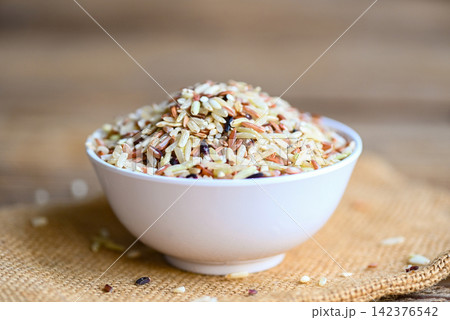 brown rice on white bowl sack background, raw various rice color mixed thai rice for cooking food , Loonzain rice brown black red white purple health food. brown rice on white bowl sack background, raw various rice color mixed thai rice for cooking food , Loonzain rice brown black red white purple health food. 142376542