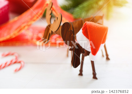 Christmas hat holiday background and decorations on christmas antlers of a deer and festive Happy New Year Christmas hat holiday background and decorations on christmas antlers of a deer and festive Happy New Year 142376852