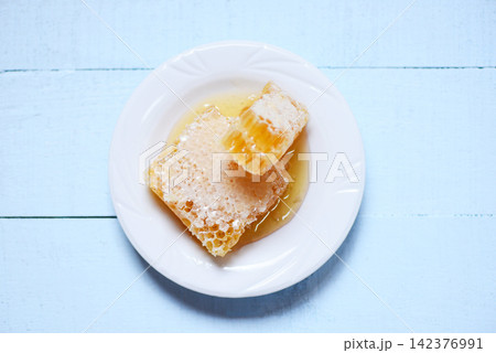 Fresh honey - Close up of yellow sweet honeycomb slice on white plate natural healthy food 142376991