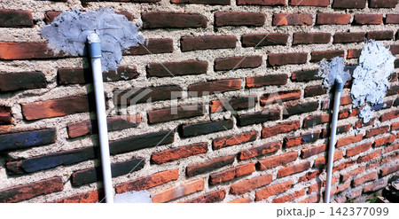 PVC water pipe installed on a red brick wall. PVC water pipe installed on a red brick wall. 142377099