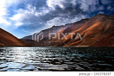 Mountain Lake Landscape with Dramatic Clouds and Rugged Peaks Mountain Lake Landscape with Dramatic Clouds and Rugged Peaks 142378287