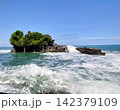 海に浮かぶ岩山の上に建つ美しいバリ島の伝統建築タナロット寺院と打ち寄せる波 海に浮かぶ岩山の上に建つ美しいバリ島の伝統建築タナロット寺院と打ち寄せる波 142379109