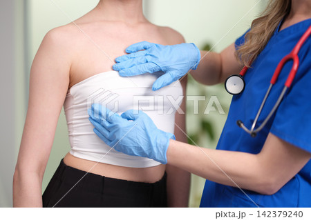 Oncologist mammologist palpating woman breast in search of tumor closeup Oncologist mammologist palpating woman breast in search of tumor closeup 142379240