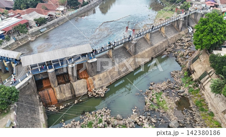 An aerial drone perspective reveals the historic Katulampa Dam spanning the Ciliwung River in Bogor at summer time An aerial drone perspective reveals the historic Katulampa Dam spanning the Ciliwung River in Bogor at summer time 142380186
