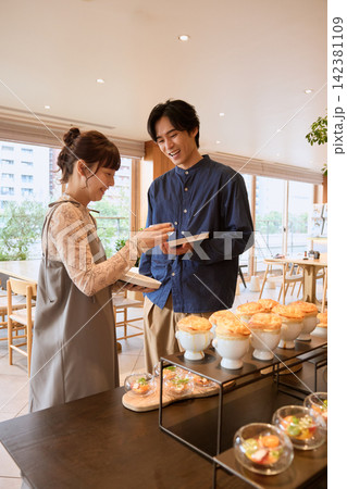 ホテルの朝食ビュッフェを楽しむ笑顔のカップル ホテルの朝食ビュッフェを楽しむ笑顔のカップル 142381109
