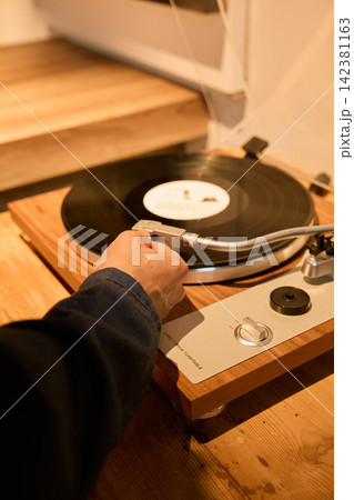 レコードプレーヤーでアナログレコードを再生する男性の手元 レコードプレーヤーでアナログレコードを再生する男性の手元 142381163