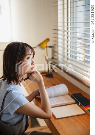 屋内で学ぶ若い女子学生 屋内で学ぶ若い女子学生 142381929