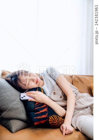 リビングでスマートフォンを使う若い女性 リビングでスマートフォンを使う若い女性 142381961