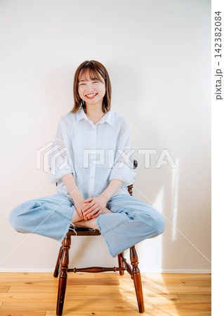 室内の椅子に座る若い女性 142382084