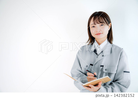 現場作業中の作業着姿の女性スタッフ 現場作業中の作業着姿の女性スタッフ 142382152