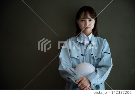 現場作業中の作業着姿の女性スタッフ 現場作業中の作業着姿の女性スタッフ 142382206