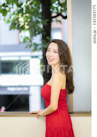 赤いドレスを着て窓際に立つ高身長ミドル美人モデル 赤いドレスを着て窓際に立つ高身長ミドル美人モデル 142384775