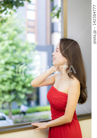 赤いドレスを着て窓際に立つ高身長ミドル美人モデル 赤いドレスを着て窓際に立つ高身長ミドル美人モデル 142384777