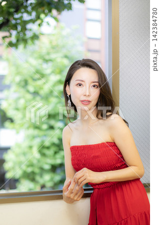 赤いドレスを着て窓際に立つ高身長ミドル美人モデル 赤いドレスを着て窓際に立つ高身長ミドル美人モデル 142384780
