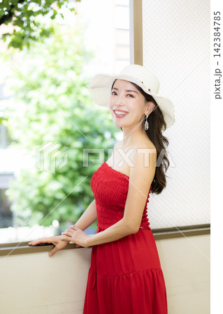 赤いドレスを着て窓際に立つ高身長ミドル美人モデル 赤いドレスを着て窓際に立つ高身長ミドル美人モデル 142384785