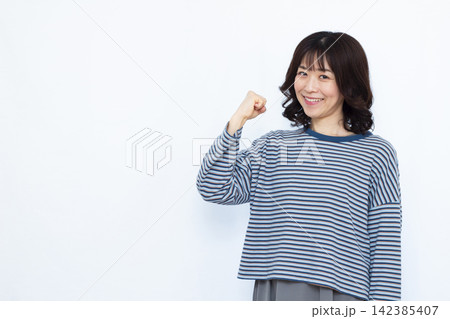 笑顔でガッツポーズをしている女性 笑顔でガッツポーズをしている女性 142385407