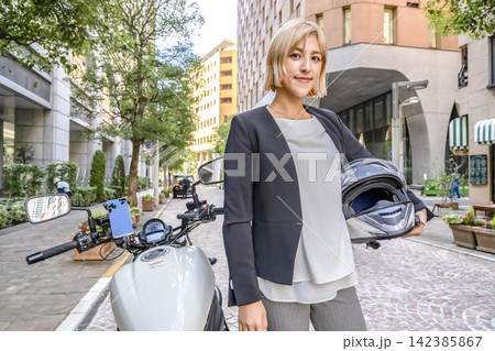 新橋イタリア街に立つ若い女性ライダーと大型アメリカンバイク 142385867