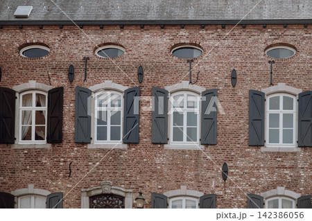 Ancient castle window with wooden shutters, European historic architecture. Medieval castle interior window with traditional shutters and rustic details Ancient castle window with wooden shutters, European historic architecture. Medieval castle interior window with traditional shutters and rustic details 142386056