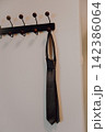 Elegant Tie Hanging on a Hanger in Minimalist Composition, Symbol of Formal Wear, Business Style, Professionalism and Sophisticated Fashion, Soft Sepia 142386064