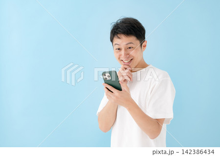 笑顔でスマホを見る男性 142386434