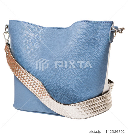 Blue leather womens handbag with patterned shoulder strap isolated on white background. Casual tote purse side view Blue leather womens handbag with patterned shoulder strap isolated on white background. Casual tote purse side view 142386892
