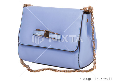 Light blue leather womens crossbody bag with gold chain strap isolated on white background. Small bow handbag side view Light blue leather womens crossbody bag with gold chain strap isolated on white background. Small bow handbag side view 142386911