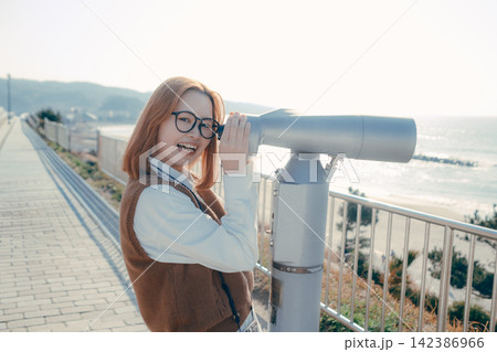 展望台の望遠鏡から海を眺める若い女性 142386966