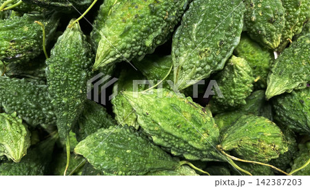 Close-up shot of green bitter melon pile with bumpy textured skin 142387203