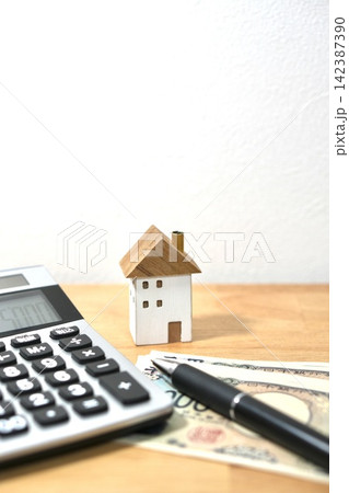 住宅購入の資金計画と家計の見直しイメージ 家の模型と電卓 住宅購入の資金計画と家計の見直しイメージ 家の模型と電卓 142387390