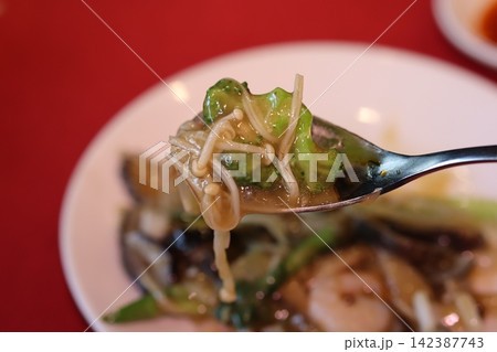 Spoonful of Broccoli and Enoki Mushrooms in Stir-Fry Dish Spoonful of Broccoli and Enoki Mushrooms in Stir-Fry Dish 142387743
