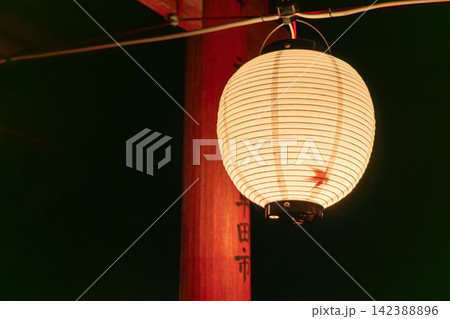 神社の境内に吊るされた丸い提灯の灯りと朱色の鳥居(もみじの影) 神社の境内に吊るされた丸い提灯の灯りと朱色の鳥居(もみじの影) 142388896