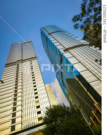 Low-angle view of modern glass skyscrapers and high-rise commercial office towers against the sky in the central business district of Jakarta, Indonesia. Low-angle view of modern glass skyscrapers and high-rise commercial office towers against the sky in the central business district of Jakarta, Indonesia. 142389223