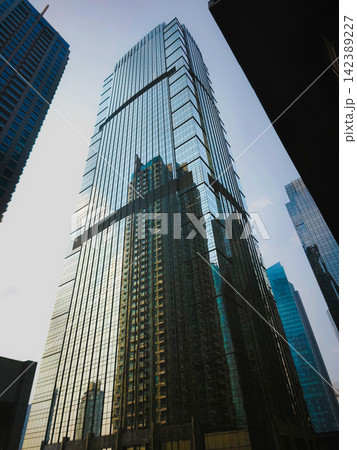 Low-angle view of modern glass skyscrapers and high-rise commercial office towers against the sky in the central business district of Jakarta, Indonesia. Low-angle view of modern glass skyscrapers and high-rise commercial office towers against the sky in the central business district of Jakarta, Indonesia. 142389227