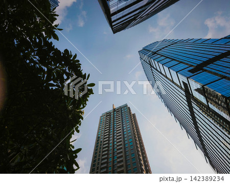 Low-angle view of modern glass skyscrapers and high-rise commercial office towers against the sky in the central business district of Jakarta, Indonesia. Low-angle view of modern glass skyscrapers and high-rise commercial office towers against the sky in the central business district of Jakarta, Indonesia. 142389234