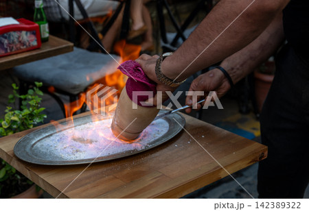 Istanbul,turkey,august 2, 2025. Chef dramatically opening a flaming testi kebab clay pot on a heated salt tray in a turkish restaurant, culinary performance Istanbul,turkey,august 2, 2025. Chef dramatically opening a flaming testi kebab clay pot on a heated salt tray in a turkish restaurant, culinary performance 142389322