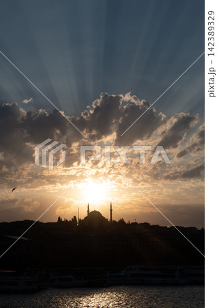 Istanbul,turkey,august 2, 2025. Istanbul city skyline at sunset, featuring a historical mosque and minarets silhouetted against a dramatic sky with sunbeams over the bosphorus Istanbul,turkey,august 2, 2025. Istanbul city skyline at sunset, featuring a historical mosque and minarets silhouetted against a dramatic sky with sunbeams over the bosphorus 142389329