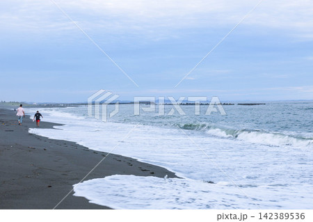 湘南の海の波うち際を散歩する人 湘南の海の波うち際を散歩する人 142389536