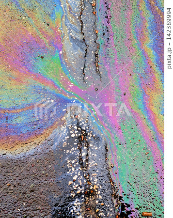 A leaked Car Oil Petrol in The Rain on a Tarmac Road Metallic Rainbow Gasoline A leaked Car Oil Petrol in The Rain on a Tarmac Road Metallic Rainbow Gasoline 142389994